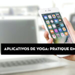 Smartphone com aplicativos de yoga na mão, em ambiente de trabalho.